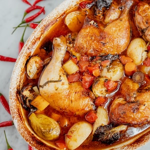 Un plat de cuisson avec un poulet rôti à la portugaise.