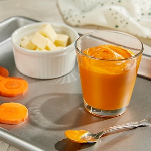 Un verre contenant de la purée de carotte.