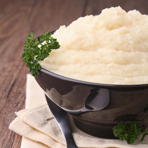 Un bol de purée de céleri-rave garnie de persil.