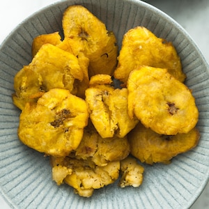 Des bananes pesées (ou plantains frits) servies dans un bol.