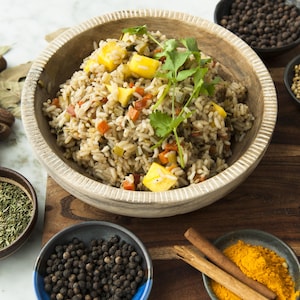 Un plat de riz créole à la mangue, entouré de bols d'épices.