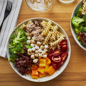 Deux bols de salades de pâtes à l’italienne sur une table.