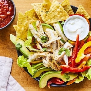 Assiette de salade de poulet grillé façon fajitas avec salsa en accompagnement.