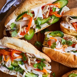 Quatre sandwichs bánh mì sur une table.