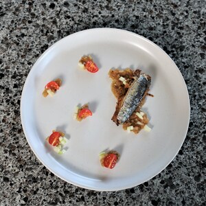 Une assiette de sardine farcie déposée sur un comptoir.