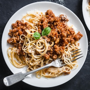 Deux assiettes de spaghetti avec une sauce bolognaise végétarienne.