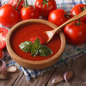 Un bol en bois contient de la sauce tomate.