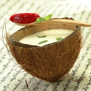 Une soupe de lait de coco au basilic et au granité de fraises servi dans une moitié de noix de coco.