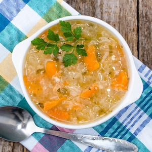 Un bol rempli de soupe aux légumes et nouilles.
