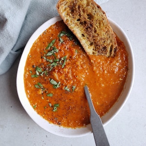 Vue en plongée d'un bol de soupe de lentilles avec un croûton et une cuillère dans le bol.