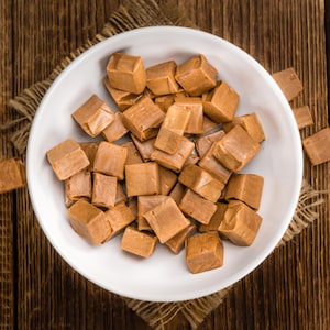 Des bonbons bruns en cubes dans une assiette.