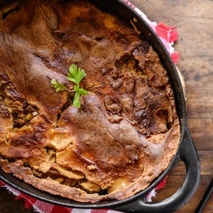 Un gros plat de tourtière sortant du four. 