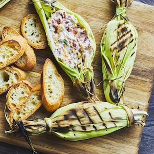 Trempette chaude dans une feuille de maïs sur une planche de bois.