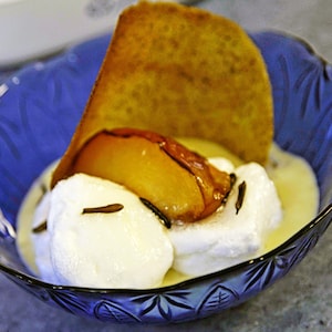 Un petit bol de crème glacée avec une tuile de riz sauvage en garniture.