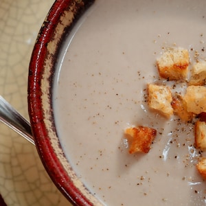 Un bol de velouté de chou-fleur et dattes, garni de croûtons.
