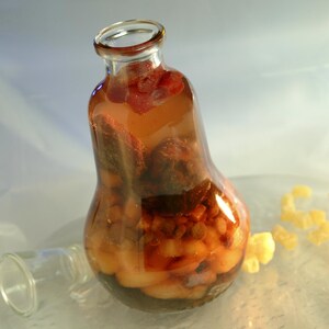 La recette de vin de fruits secs et de pimbina dans une bouteille en verre en forme d'ampoule.