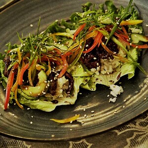 Plusieurs légumes et du bison sur des feuilles de salade.