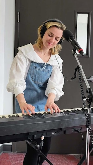 Viviane Audet derrière son clavier dans un studio de radio.
