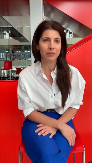 La journaliste Caroline Lacroix est assise sur un tabouret. 
