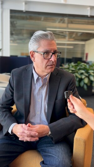 Un homme d'âge mur répondant aux questions d'une journaliste.