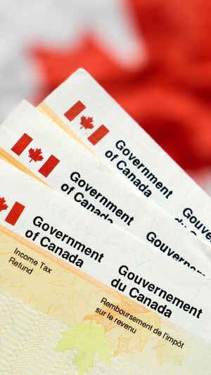 Des documents de remboursement de l'impôt sur le revenu devant un drapeau canadien.