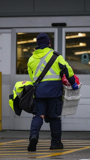 Une personne qui travaille à Postes Canada retourne travailler à un entrepôt de Vancouver, le 17 décembre 2024.