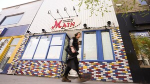 Un homme marchant devant la façade d'un restaurant.