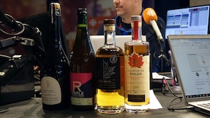 Quatre bouteilles d'alcool disposées sur une table.