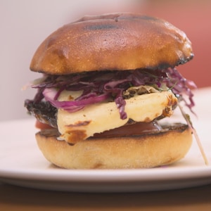 Un burger au champignon et au fromage avec salade de chou dans une assiette.