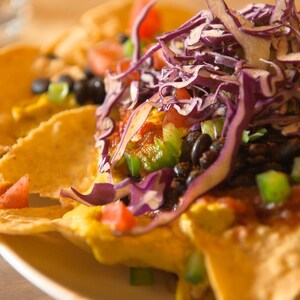 Des nachos avec une sauce aux graines de tournesol et des légumes.