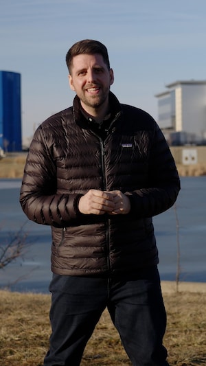 Le journaliste se trouve devant des centres de données. 