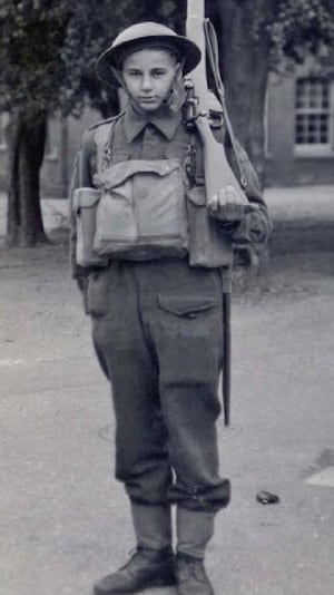 Un jeune homme habillé de son habit de soldat.