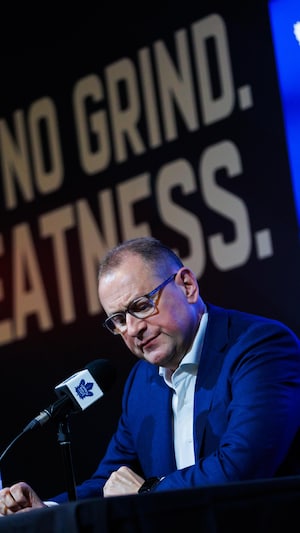 Brad Treliving au podium lors de son point de presse, devant des logos de l'équipe.