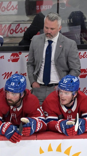 Quatre joueurs du Canadien sont assis sur leur banc.