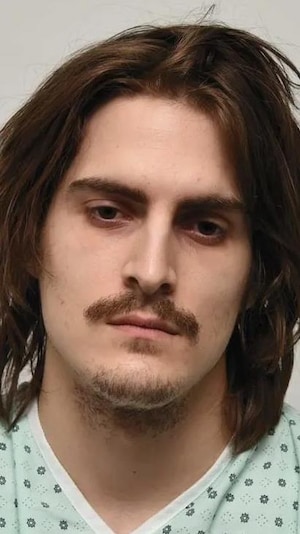 Photo d'identification d'un homme aux cheveux longs en robe d'hôpital.