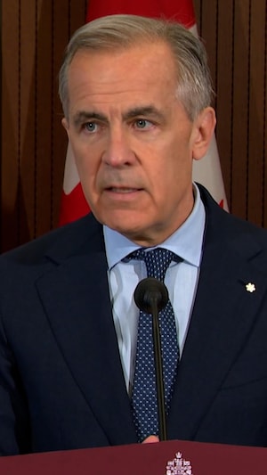 Mark Carney derrière un micro.