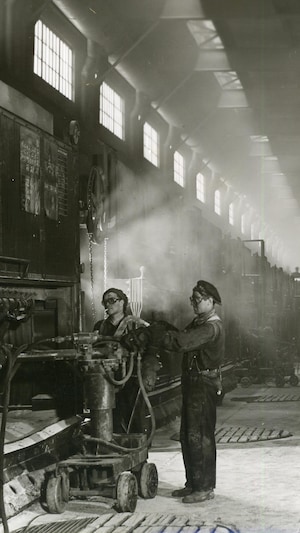 Des travailleurs de l'usine d'Arvida dans les salles de cuves. Vue d'une grande salle avec plusieurs cuves.