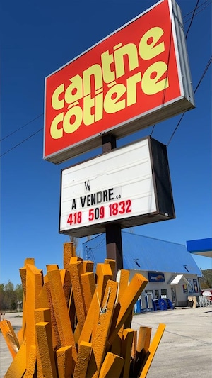 Un panneau affichant à vendre devant la Cantine côtière.