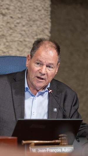 Jean-François Aubin assis à la table du conseil.