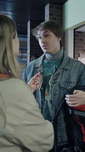 Une journaliste tend son micro vers un étudiant présent lors de la distribution de bacs alimentaires à l'Université du Québec à Montréal.