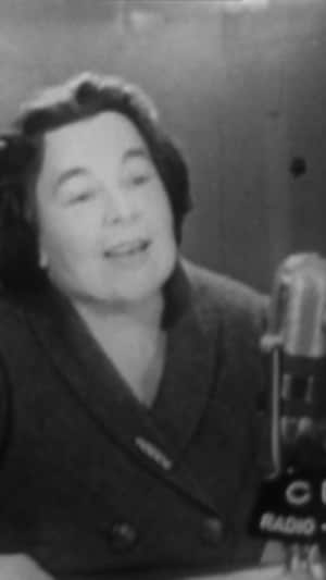 Une femme en train de parler au micro d'une radio.