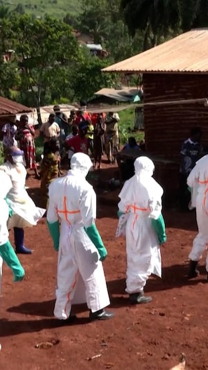 Des personnes portent des blouses et équipements de protection.