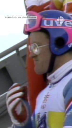 Un homme en tenue de saut à ski s'apprête à sauter.