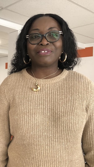 Geneviève M'Boua pose dans son épicerie.