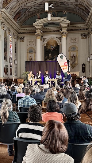 Des festivaliers qui écoutent une conférence.