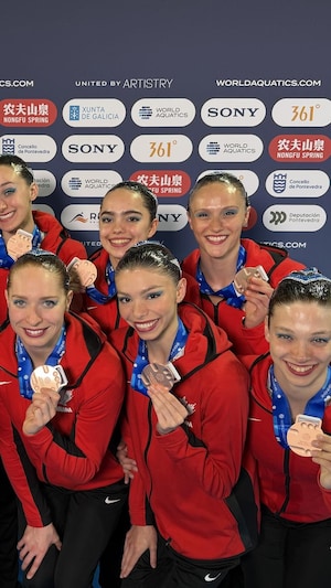 Des nageuses tiennent leur médaille de bronze.