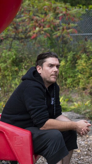 Philippe Aubin est assis dans la glissade d'un parc pour enfants.