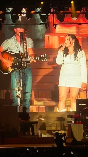 Learyn Sylvestre-Piche, alias Lea McK, sur la scène du Festival Country Thunder de Craven, en Saskatchewan, aux côtés de la vedette américaine Riley Green.