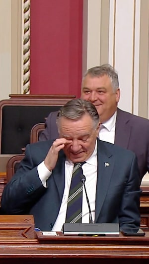François Legault, émotif, se frotte un oeil. 