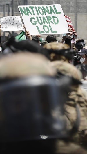 Des soldats de la Garde nationale montent la garde alors que des manifestants se rassemblent devant le Metropolitan Detention Center, le 8 juin 2025 à Los Angeles, Californie.